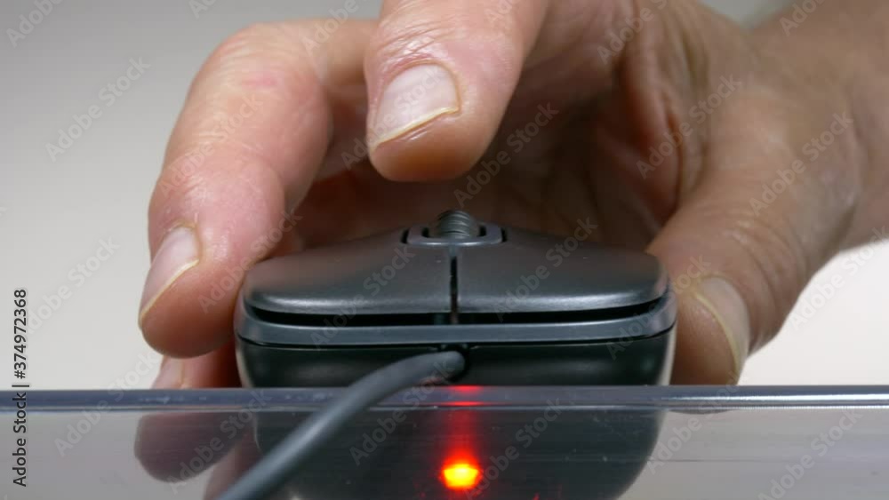 Closeup POV shot of a man’s hand holding a computer mouse on a