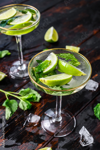 Fresh drink lemonade mojito. Mojitos with mint leaves, lime and ice. Black wooden background. Top view