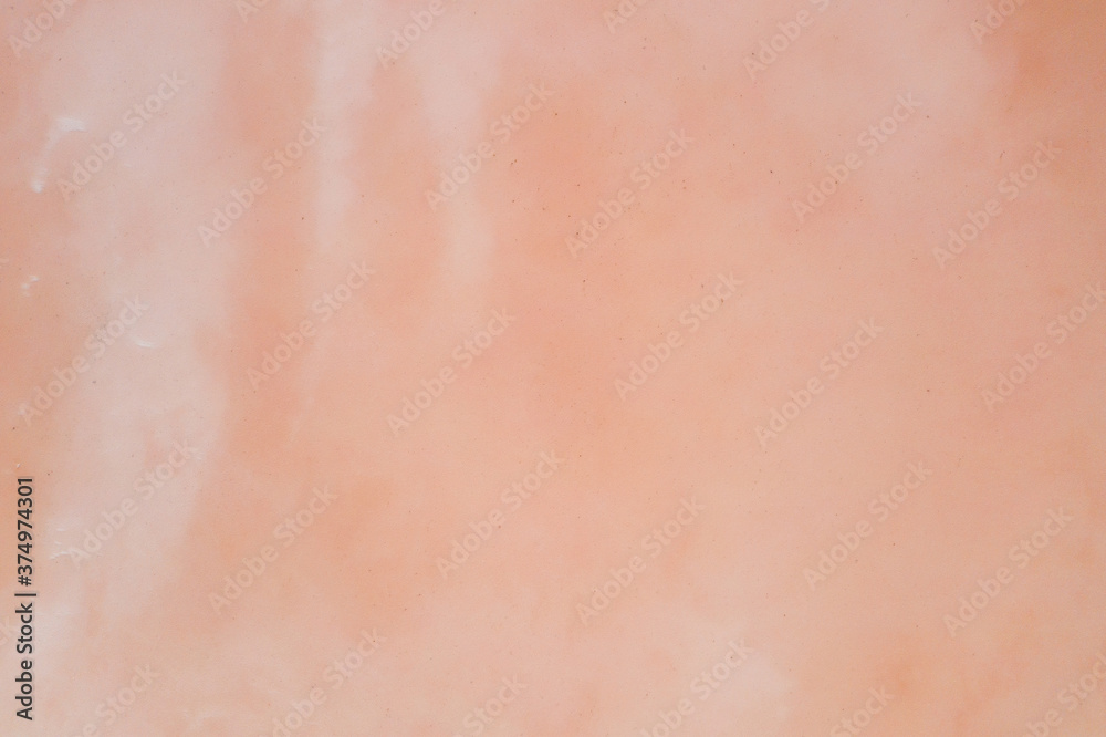 Non-uniform pale pink surface of a salty reservoir. Texture. Shooting from a drone.