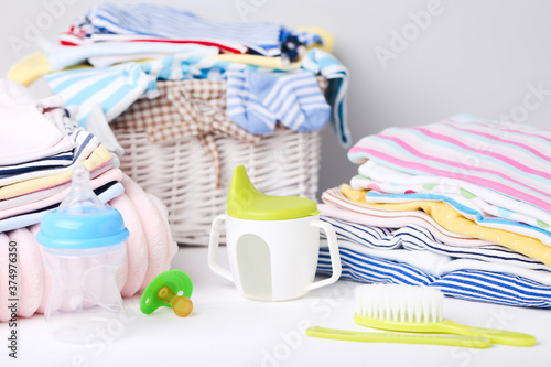 Colorful clothes with baby supplies on white background