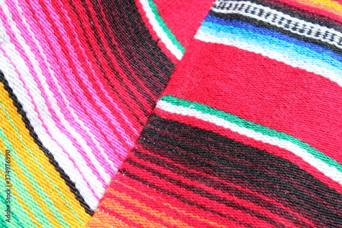 Mexican cinco de mayo poncho Mexico serape background dia de los Muertos Mexican poncho blanket rug fiesta traditional with stripes copy space - stock photo photograph