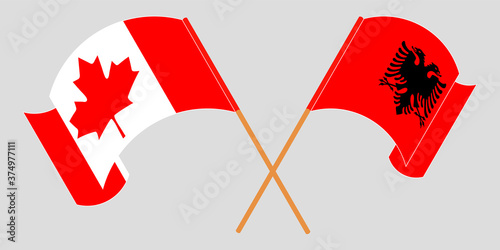 Crossed and waving flags of Albania and Canada