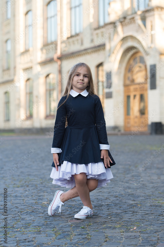 Fototapeta premium Practice makes perfect. Little kid make curtsy outdoors. Small ballerina wear uniform. Back to school fashion. Formal dress code. September 1. Back to school. Dance education. Dancing is perfection