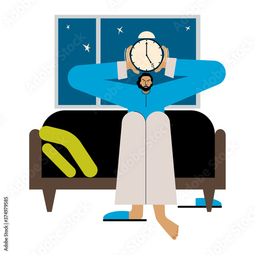 A tired man sits in bed early in the morning with an alarm clock in his hands.