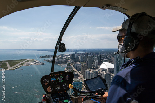 pilot in cockpit, city of Toronto. Helicopter