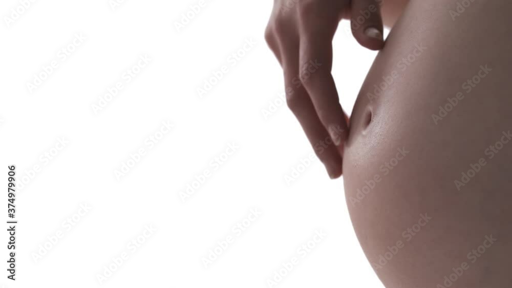 Macro shot of pregnant Caucasian woman's belly. Caring mother sliding her fingers across stomach. Healthy pregnancy concept. Isolated on white background. Macro shot of pregnant Caucasian woman's belly. Caring mother sliding her fingers across stomach. Healthy pregnancy concept. Isolated on white background.