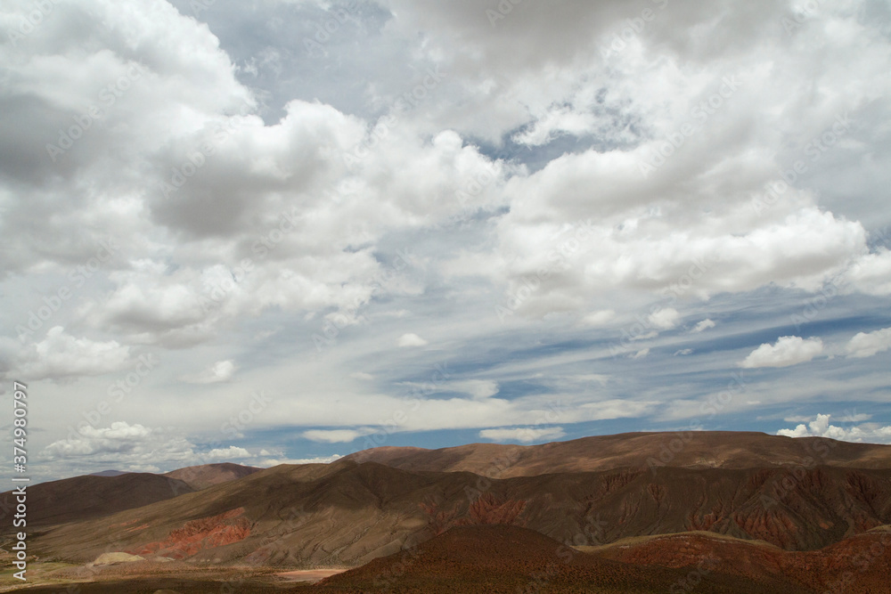 Desert landscape. Aerial view of the brown arid mountains and valley under a beautiful cloudy sky.