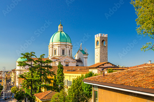 Dome of Santa Maria Assunta New Cathedral, Duomo Nuovo Roman Catholic church and Clock Tower of Palazzo del Broletto palace, clear blue sky, Brescia city historical centre, Lombardy, Northern Italy photo