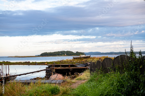 landscape of the island against the background of old wooden boats lying on the shore © константин константи
