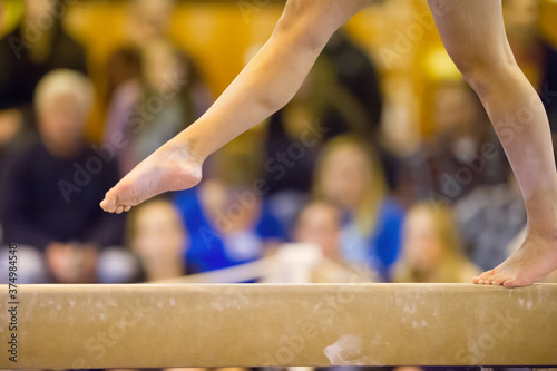 Close-up of Gymnasts feet on beam with crowd in background