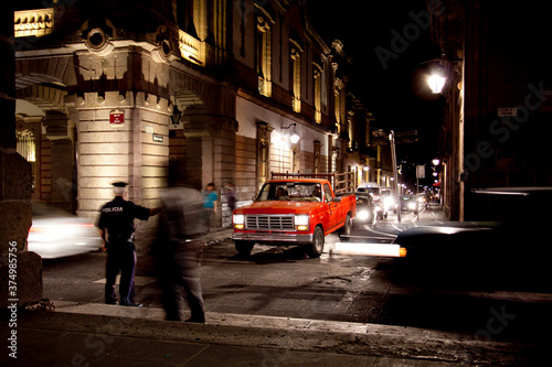 Tableau sur toile Busy street at night time controlled by a police man