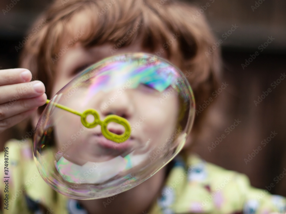 Young boy at play blowing bubble Young boy at play blowing bubble