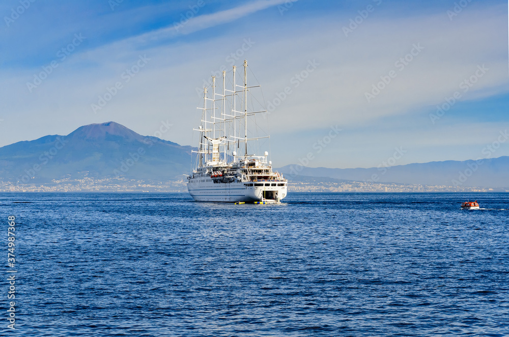 Modern sailing ship on the open sea against the backdrop of the mountains of the Amalfi coast. Amalfi, Italy