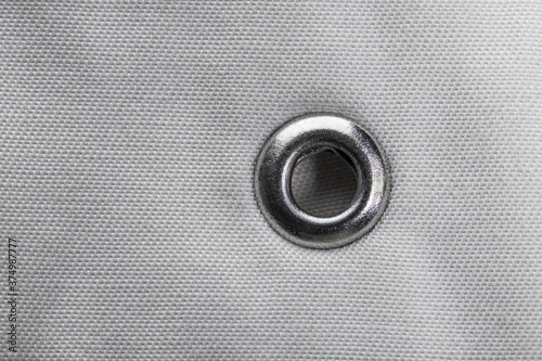фотографія metal grommet on grey raincoat fabric