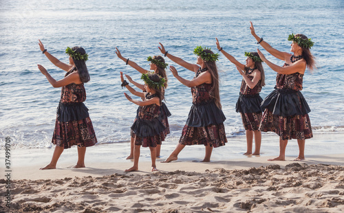 Group of traditional Hawaiian hula dancers performing on the beach in Maui photo