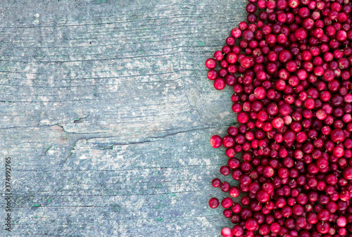 Lingonberry berries on an old wooden board. Place for your text.
