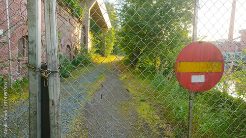 A closed gate with a padlock preventing entry