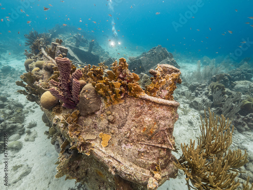 Ship wreck "Tugboat Saba" in  shallow water of coral reef in Caribbean sea / Curacao with diver in background

