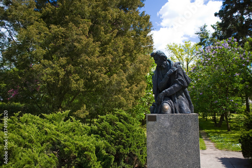 stone statue of Fryderyk Chopin against the background of a green park