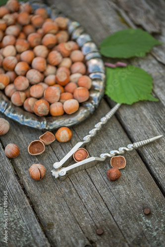 Hazelnuts on a vintage dish on a wooden table. Chop nuts, top view.