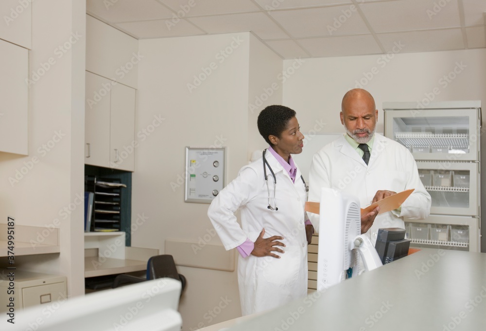 Doctors discussing files in office