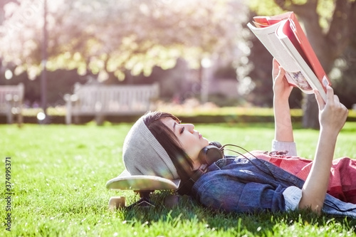 Asian college student studying while lying down on the grass photo