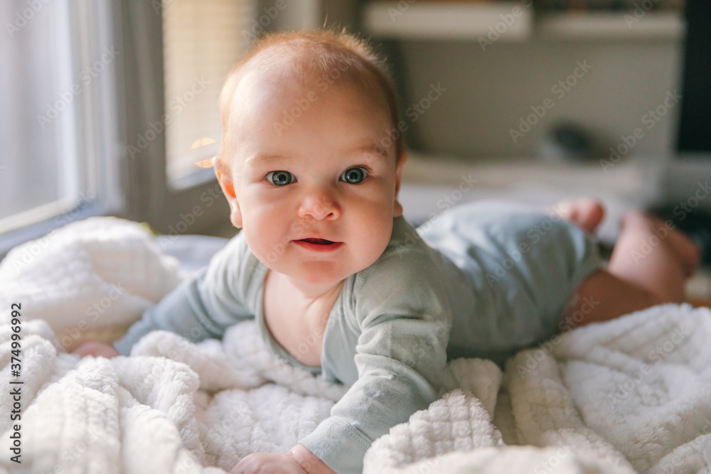 A three-month-old baby lies on his stomach A three-month-old baby lies on his stomach