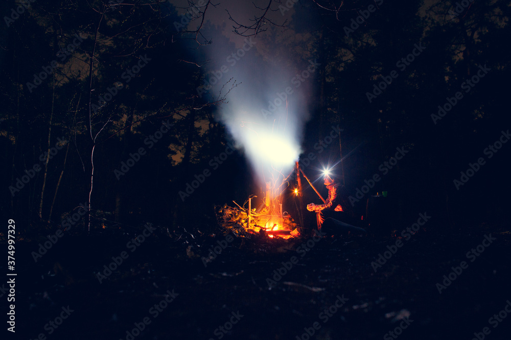 Someone sitting next to a camp fire at night Someone sitting next to a camp fire at night