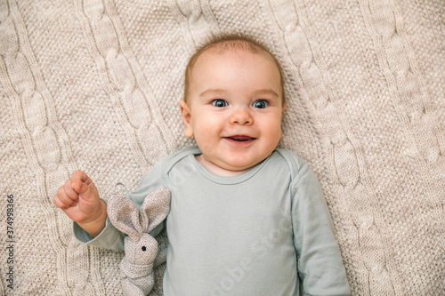 Newborn baby three months old smiles and lies on a white blanket. Psychomotor development and baby care photo