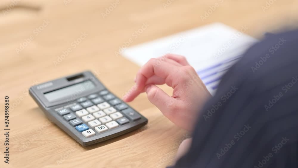 Rear View of Hands using Calculator in Close up Rear View of Hands using Calculator in Close up