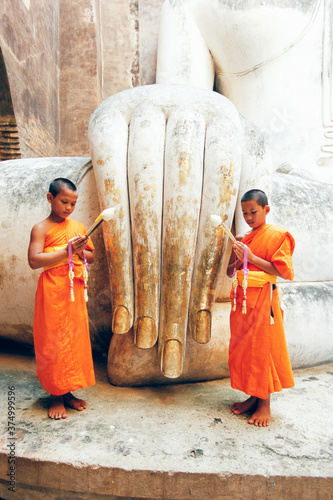 Novice monks and Phra Atchana Buddha statue, Wat Si Chum, Sukhothai, UNESCO World Heritage Site, Sukhothai Province, Thailand, Asia photo