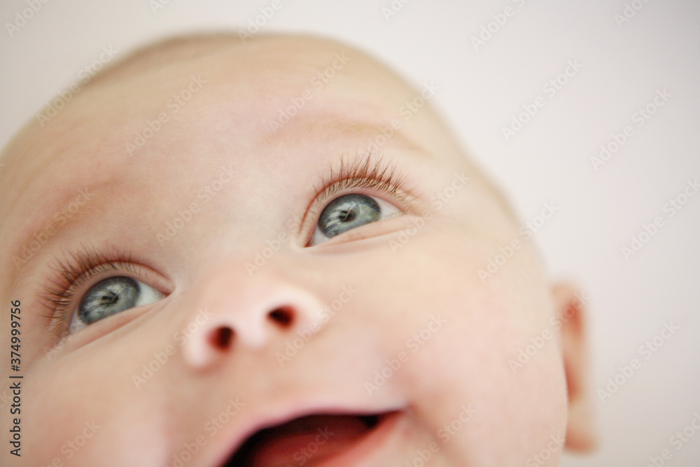 Close up of blue eyed baby with curly eyelashes and smile Close up of blue eyed baby with curly eyelashes and smile
