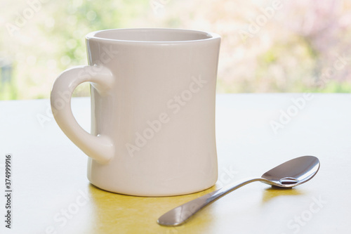 Retro coffee mug with spoon on diner counter near a window