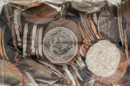 Abstract macro showing glass jelly jar filled with various coins. photo
