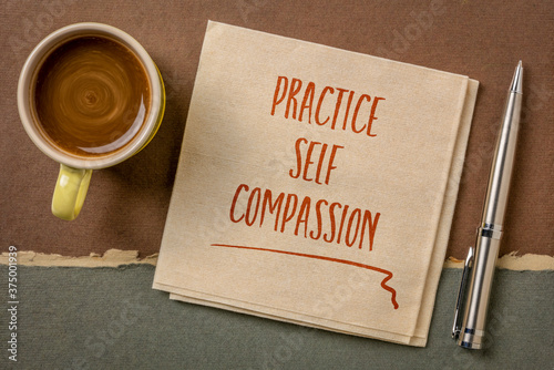 practice self-compassion inspirational handwriting on a napkin with coffee, mindset and personal development concept photo