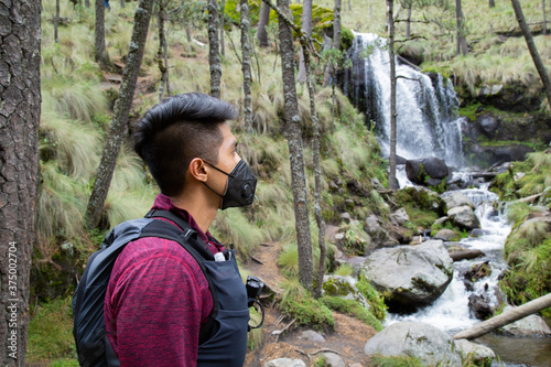 wearing a mask ,Man looking at the Waterfall in Izta-Popo Zoquiapan National Park photo