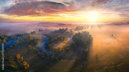 Mystical morning river, the sun's rays shine through the fog.