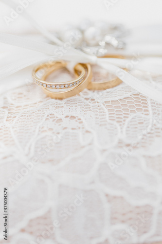 Two gold wedding bands tied with ribbon