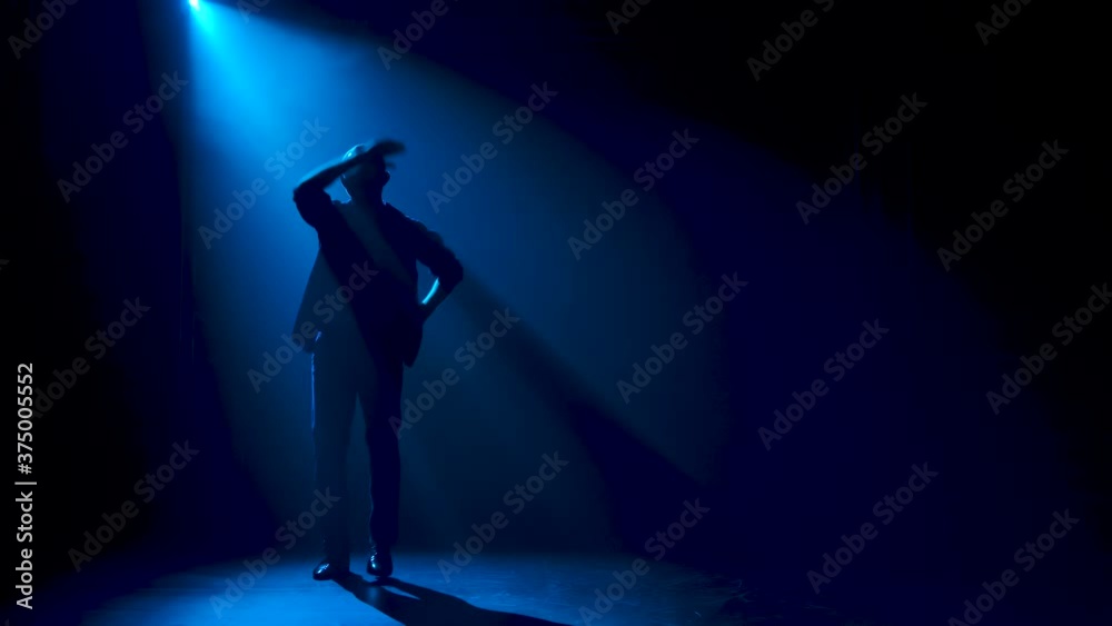 Man dancing latin music. Bachata, merengue, salsa. Shot in a dark studio with neon lights in the background. Man dancing latin music. Bachata, merengue, salsa. Shot in a dark studio with neon lights in the background.