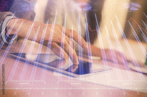 Double exposure of forex graph drawing and man and woman working together holding and using a mobile device. Trade concept.