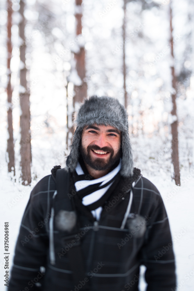 Young man smiling in snowy forest Young man smiling in snowy forest