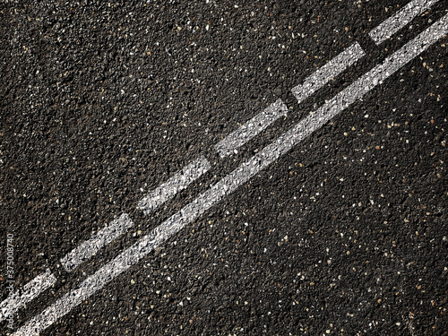 Foto Dotted and solid double white lines on asphalt road.
