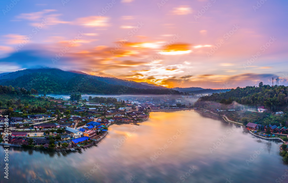 Aerial view reflection of sunrise and misty at Ban Rak Thai Chinese village and reflection on lake at twilight in Mae Hong Son, Thailand