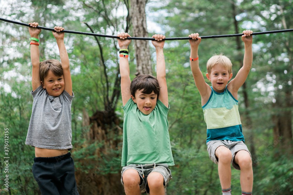 Three monkey boys playing on tire swings at summer camp Three monkey boys playing on tire swings at summer camp