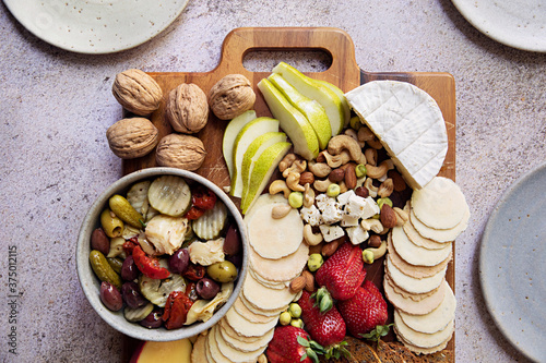 Overhead photo of a meat and cheese platter with fruit and nuts photo