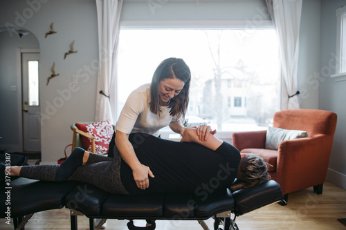 Young woman chiropractor giving treatment.
