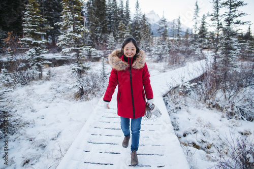 Young woman outside in winter wearing red coat and holding figur photo