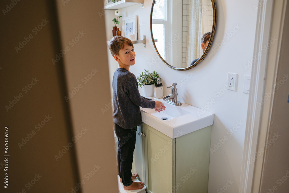Young boy washing hands in bathroom at home. Young boy washing hands in bathroom at home.