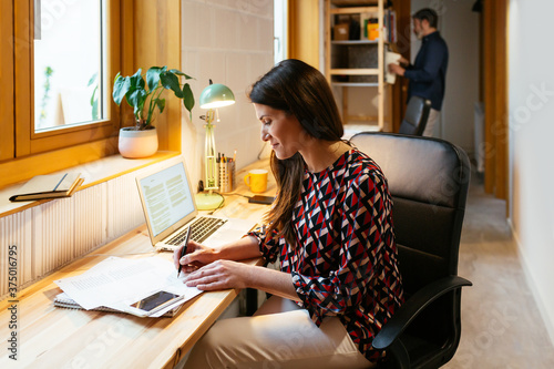 Female freelancer making notes near husband