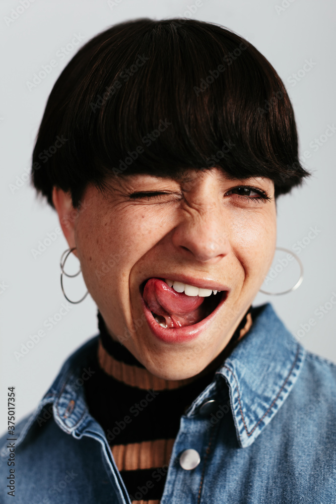 Stylish woman sticking the tongue at camera Stylish woman sticking the tongue at camera